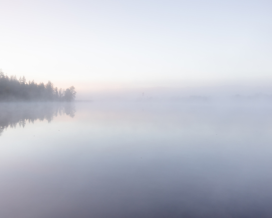 Ein See bedeckt mit Nebel