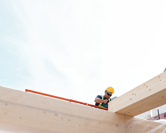 Ein Arbeiter auf einem Holzbalken
