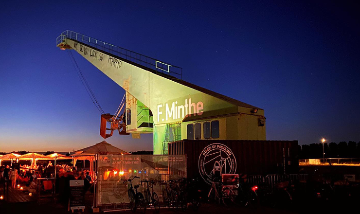 Der Biergarten kurz nach Sonnenuntergang mit einem Kran im Hintergrund
