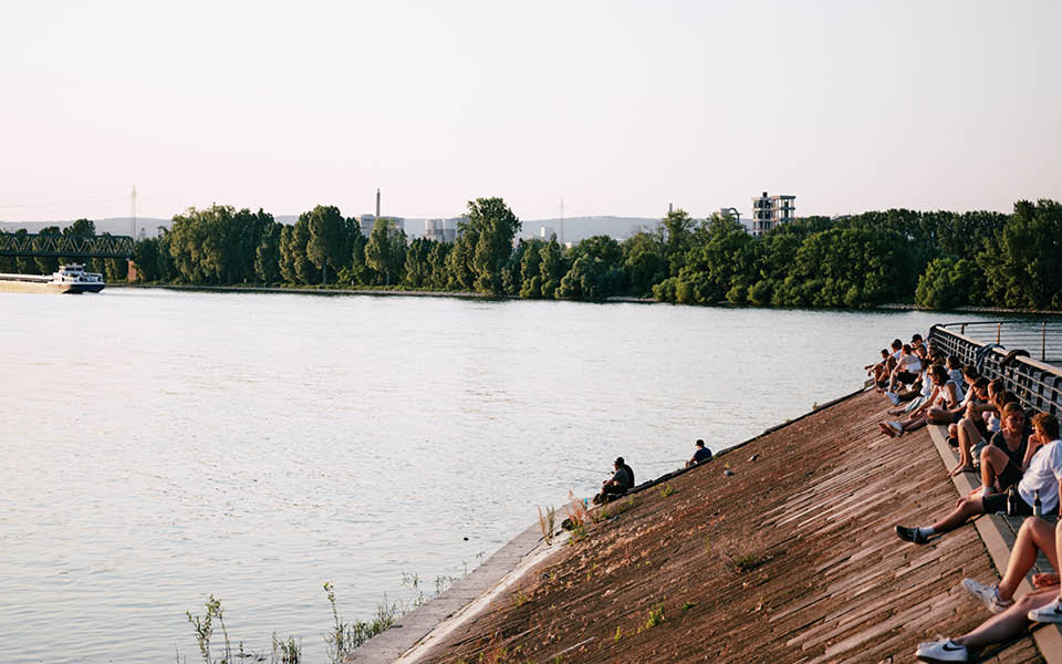 Viele junge Leute sitzen beim Wasser
