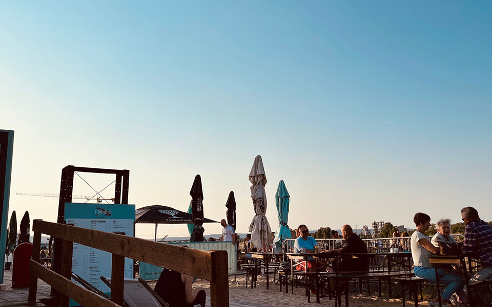 Leute sitzen an einer Strandbar am späten Nachmittag